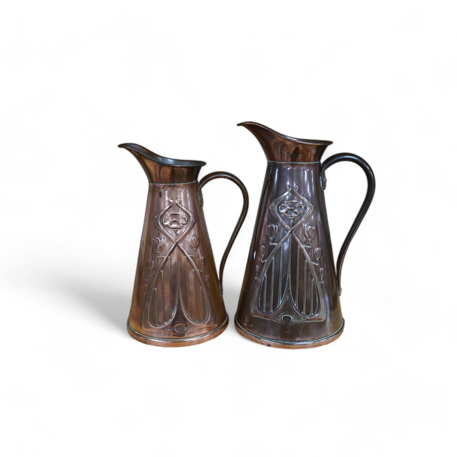 Two Joseph Sankey Art Nouveau embossed copper jugs, tallest 23cm. Condition- fair to good